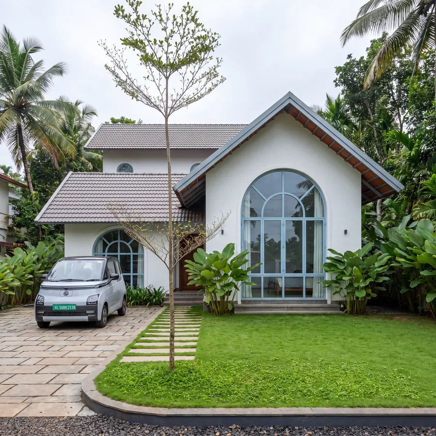 White Gable House by Claycode Architects: white gable with tall arched window and lawn