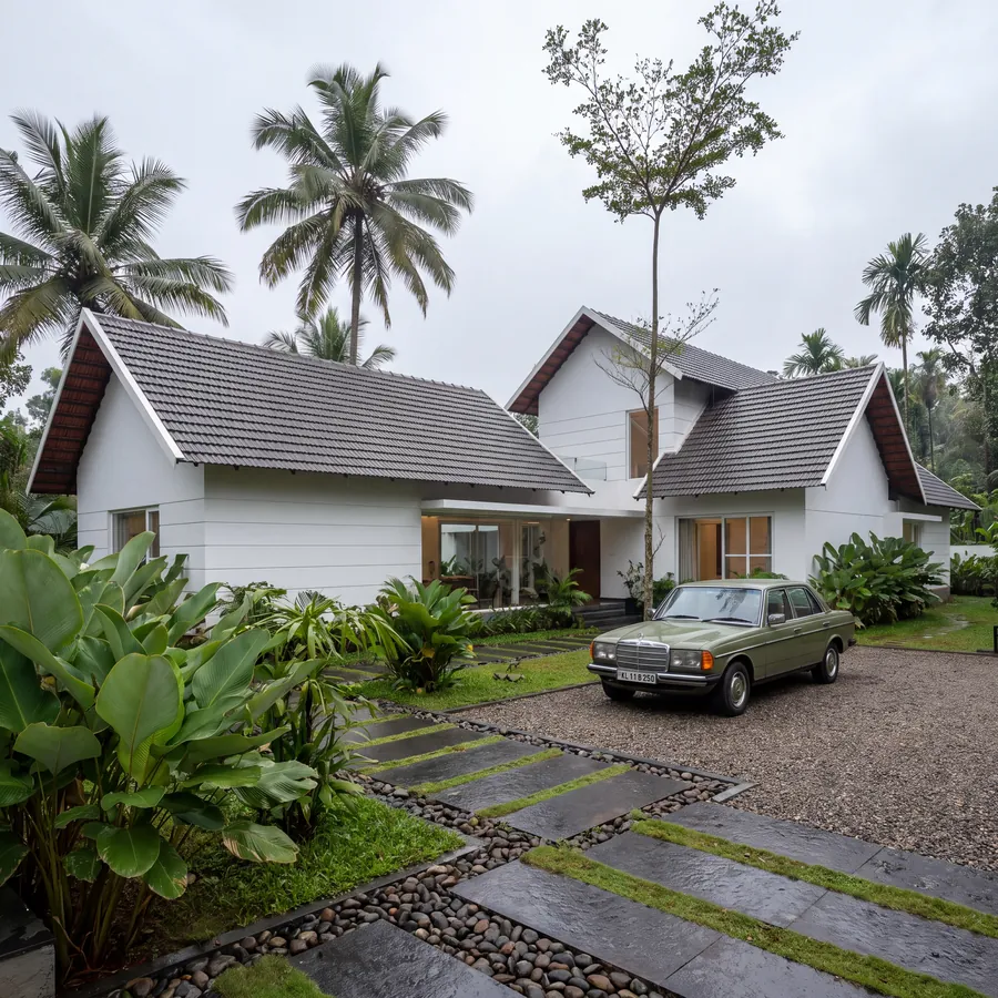 White Gable House: white gabled wings with dark tiled roofs and gravel drive